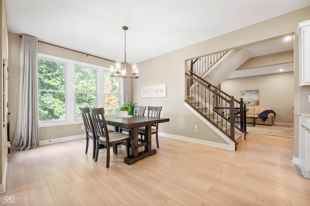 dining space with an inviting chandelier and light hardwood / wood-style floors