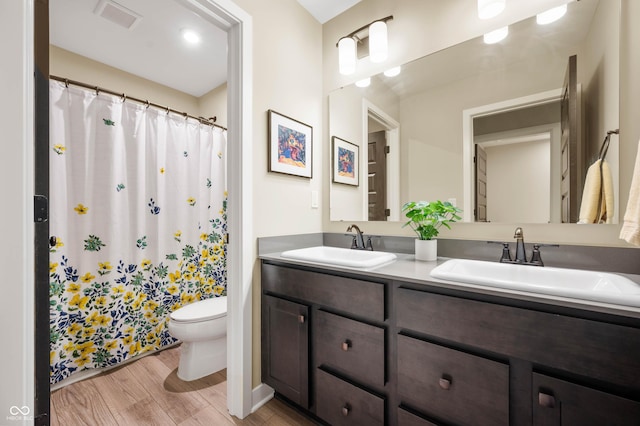 bathroom featuring hardwood / wood-style flooring, vanity, and toilet