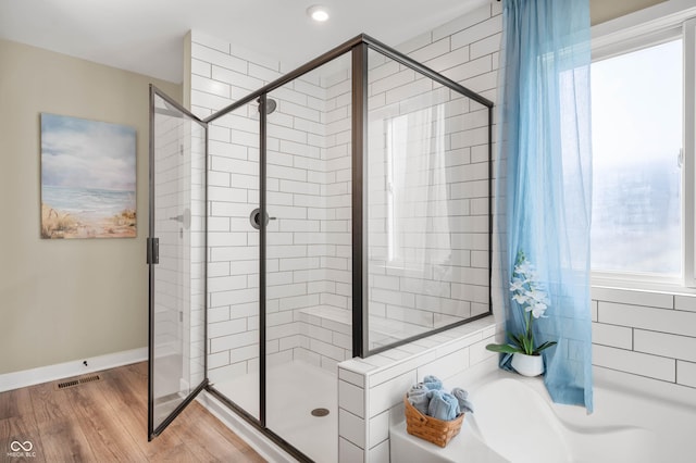 bathroom featuring hardwood / wood-style flooring and plus walk in shower