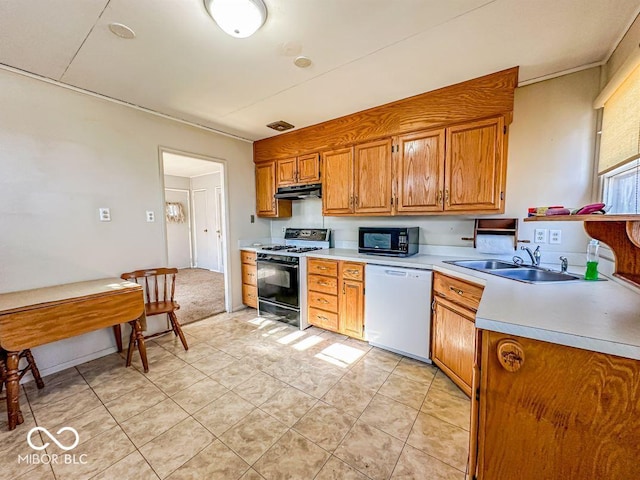 kitchen featuring dishwasher, sink, gas range oven, and light tile patterned floors