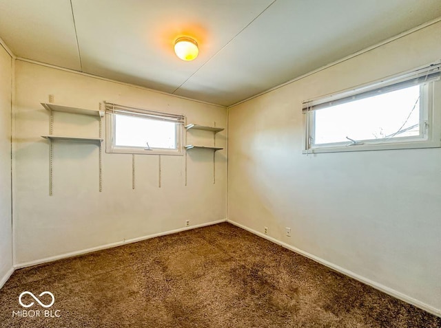 unfurnished room with a healthy amount of sunlight and dark colored carpet