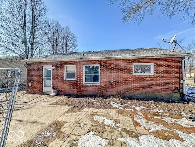 snow covered rear of property with a patio