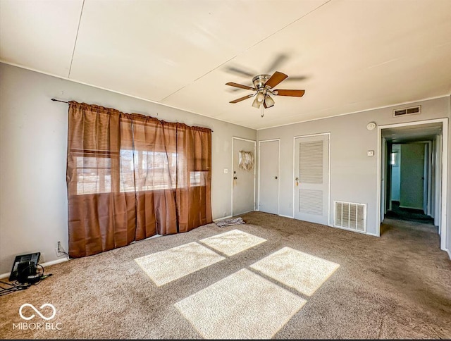 unfurnished bedroom featuring multiple closets, ceiling fan, and carpet flooring