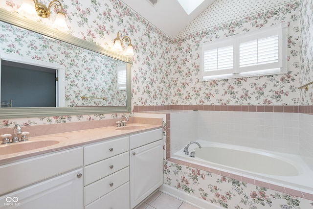 bathroom featuring a relaxing tiled tub, vanity, lofted ceiling with skylight, and tile patterned flooring