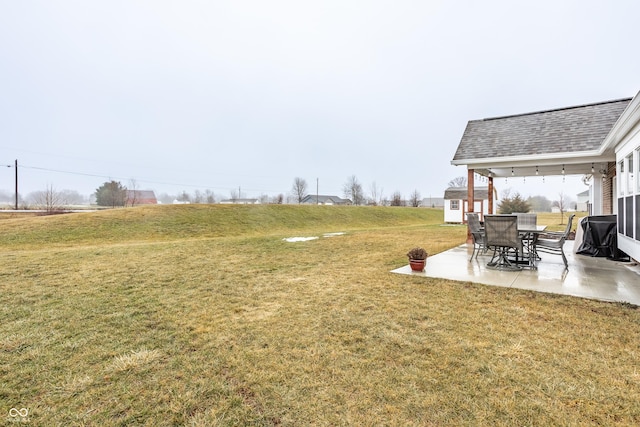 view of yard featuring a shed, a patio area, and a rural view