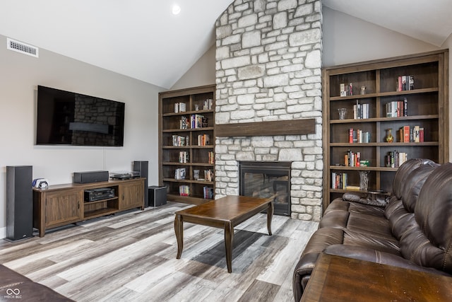 living room featuring light hardwood / wood-style flooring, a fireplace, and high vaulted ceiling