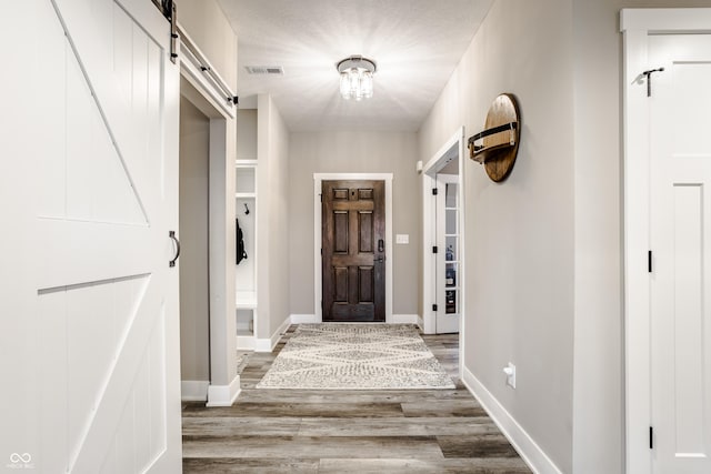 hall featuring wood-type flooring and a barn door