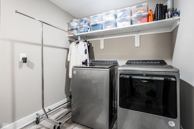 clothes washing area featuring independent washer and dryer and light hardwood / wood-style floors