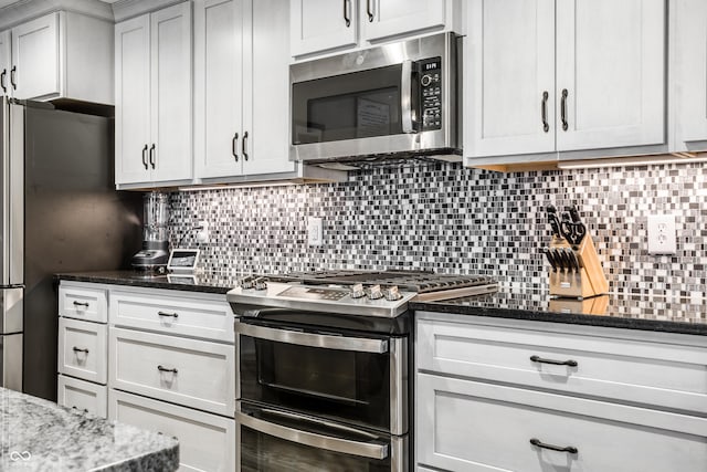 kitchen featuring tasteful backsplash, stainless steel appliances, and dark stone countertops