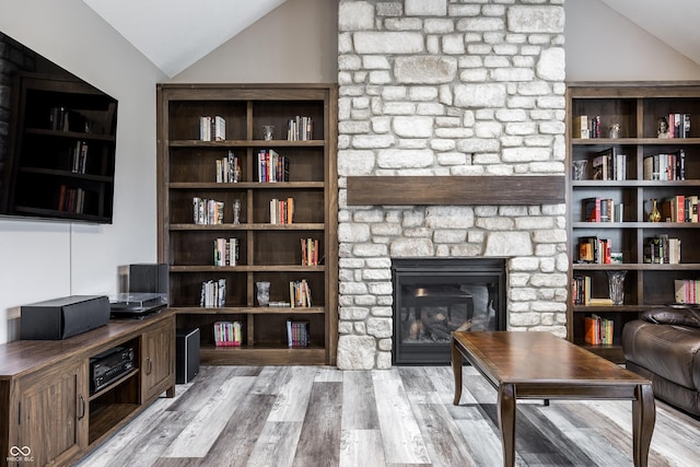 interior space with lofted ceiling, a fireplace, and light hardwood / wood-style floors