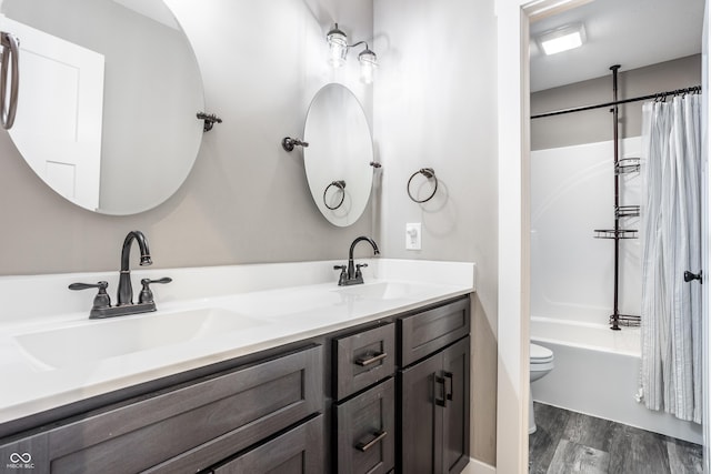 full bathroom featuring hardwood / wood-style flooring, vanity, toilet, and shower / bath combo