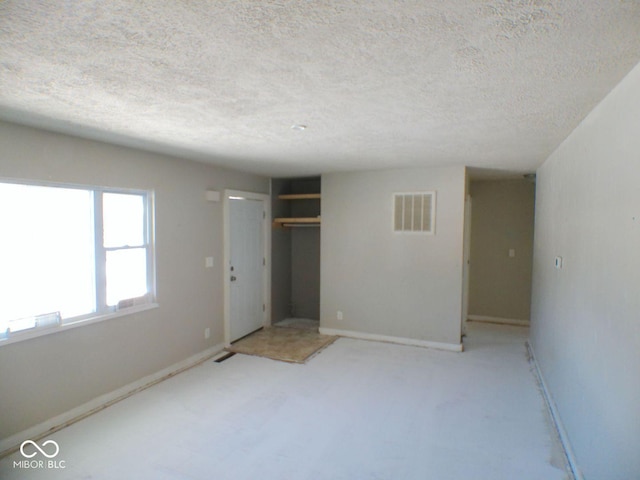 unfurnished bedroom with a textured ceiling and a closet