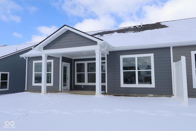 view of snow covered back of property