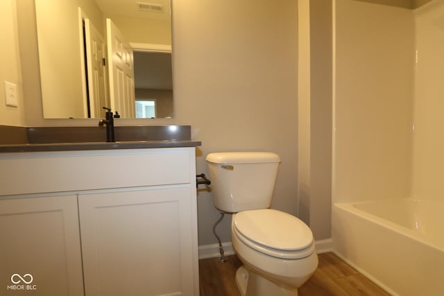 bathroom with vanity, hardwood / wood-style floors, a washtub, and toilet