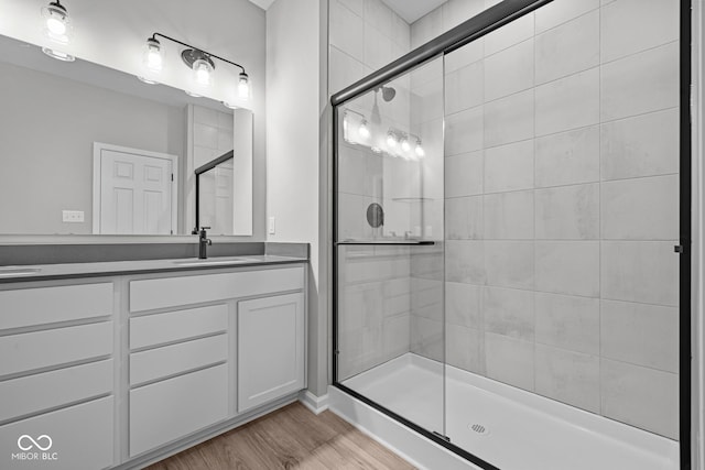 bathroom with wood-type flooring, vanity, and walk in shower