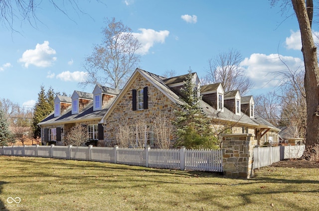 view of property exterior with a yard, stone siding, and a fenced front yard