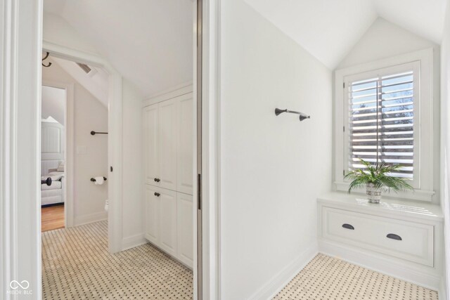 bathroom with vaulted ceiling, toilet, baseboards, and tile patterned floors