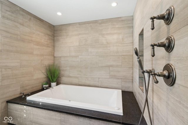 full bathroom with a bathing tub, tile walls, and a tile shower