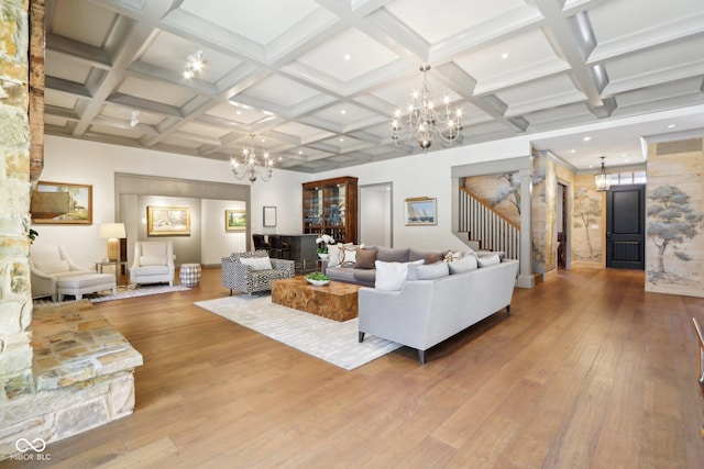 living area with beamed ceiling, wood finished floors, coffered ceiling, and a chandelier