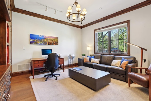 office space with baseboards, visible vents, an inviting chandelier, ornamental molding, and light wood-style floors