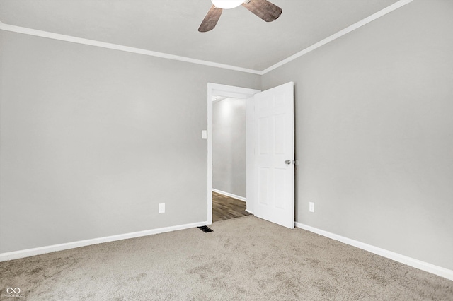 empty room featuring crown molding, carpet flooring, and ceiling fan