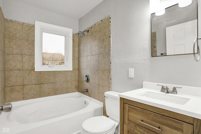 full bathroom featuring tiled shower / bath, vanity, and toilet