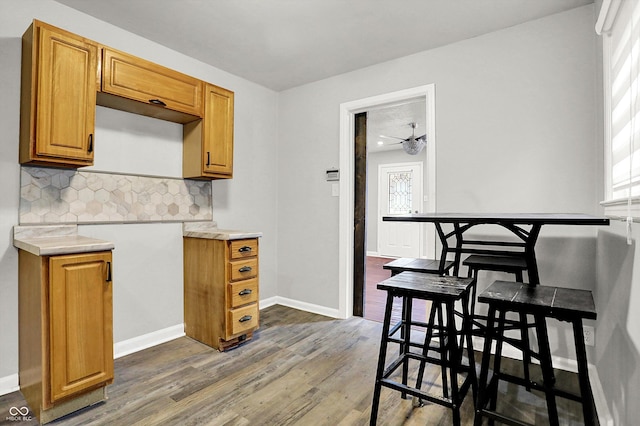 kitchen with backsplash, dark wood-type flooring, and ceiling fan