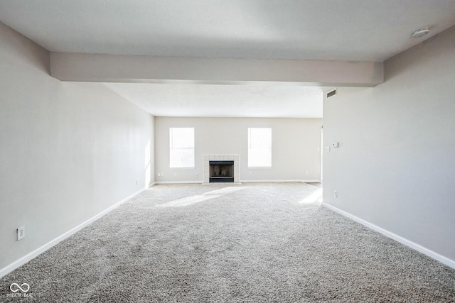 unfurnished living room with a fireplace and carpet