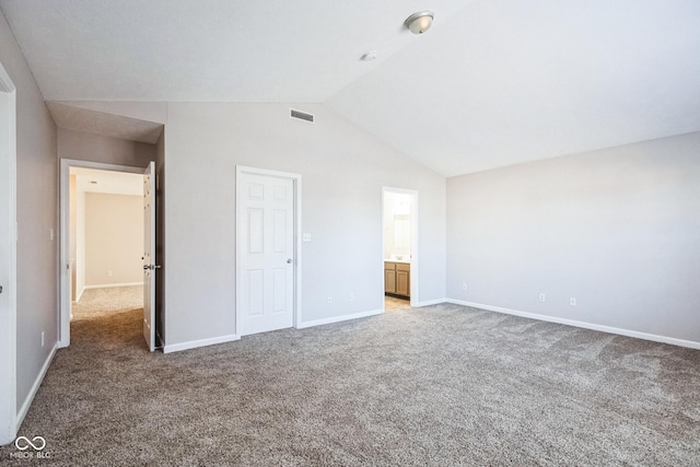 unfurnished bedroom featuring ensuite bath, lofted ceiling, and carpet