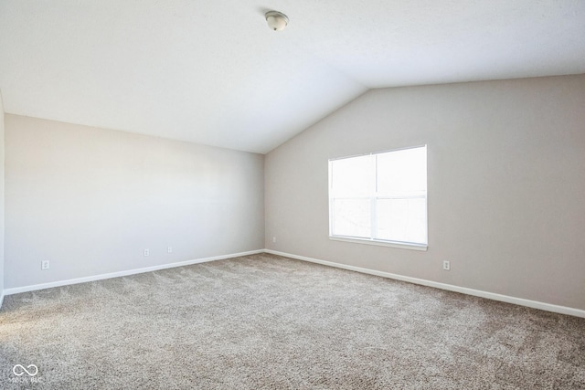 unfurnished room with lofted ceiling and carpet flooring