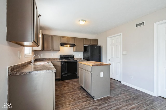 kitchen featuring dark wood-type flooring, butcher block counters, sink, a center island, and black appliances