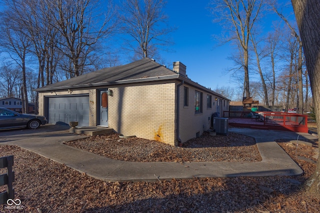 view of property exterior featuring a garage and central AC unit