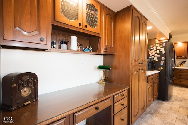 kitchen featuring ornamental molding and stainless steel refrigerator