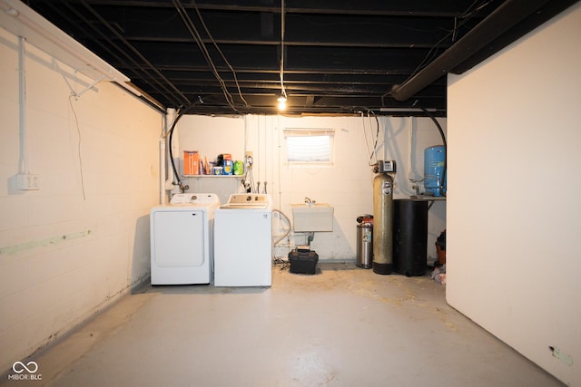 basement with sink and washing machine and dryer