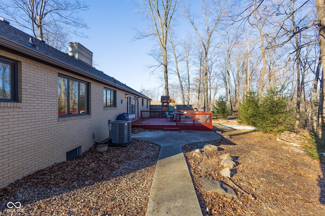 view of yard featuring a wooden deck and central AC unit