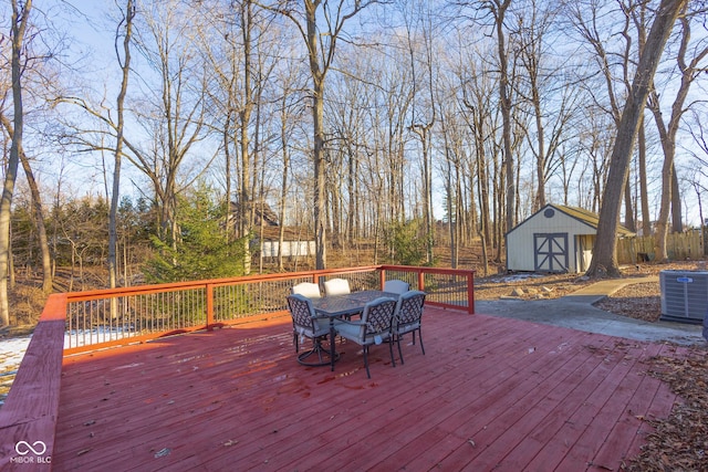 wooden terrace featuring cooling unit and a shed