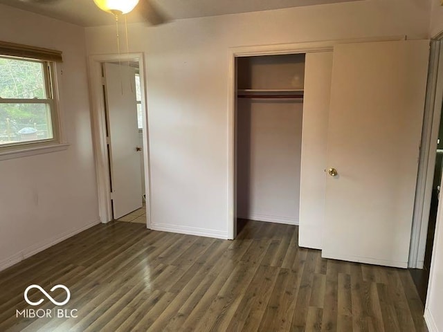 unfurnished bedroom with dark hardwood / wood-style flooring and a closet