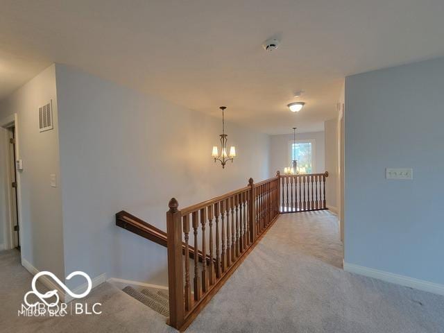 stairs featuring carpet and an inviting chandelier