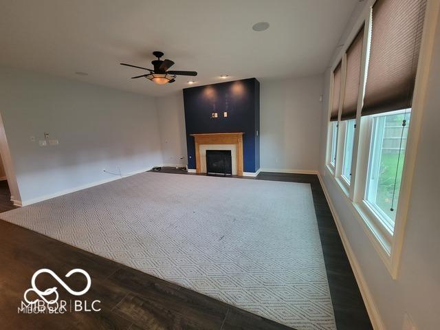 unfurnished living room with ceiling fan