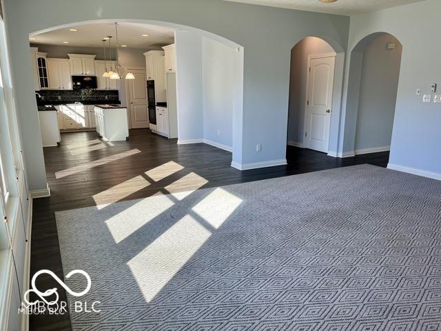 unfurnished living room with dark hardwood / wood-style flooring