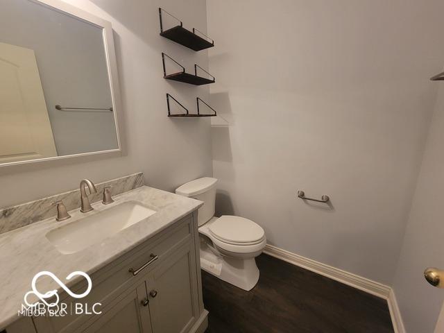 bathroom with vanity, toilet, and wood-type flooring