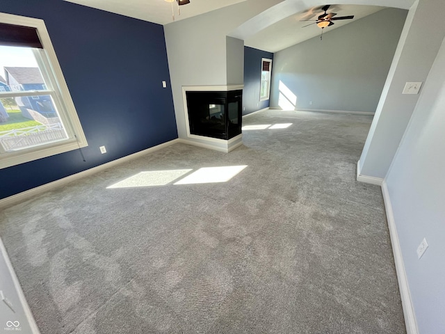 unfurnished living room featuring vaulted ceiling, light colored carpet, ceiling fan, and a multi sided fireplace