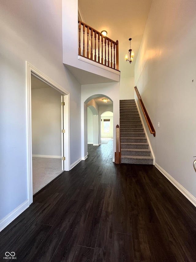 interior space featuring dark hardwood / wood-style floors, a chandelier, and a high ceiling