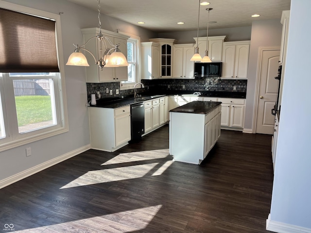 kitchen with pendant lighting, white cabinetry, a kitchen island, and black appliances