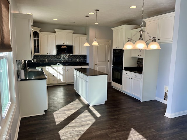 kitchen featuring pendant lighting, white cabinetry, and a center island