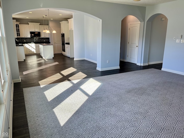 unfurnished living room featuring dark wood-type flooring