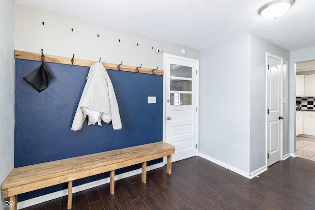 mudroom with baseboards, a textured ceiling, and wood finished floors