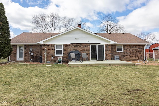 back of property featuring a yard, cooling unit, a shingled roof, a wooden deck, and brick siding