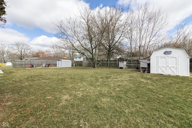 view of yard featuring an outbuilding, a storage unit, and fence