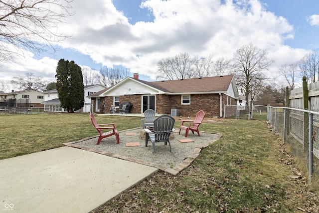 back of property with a fenced backyard, a chimney, a patio area, a lawn, and brick siding